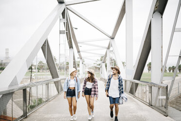 Spanien, Barcelona, drei glückliche Freunde, die Seite an Seite auf einer Brücke gehen - JRFF000069