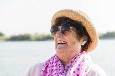 Porträt einer lächelnden älteren Frau mit Sonnenbrille und Sommerhut - UUF005709