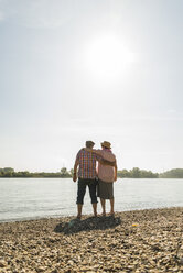 Deutschland, Ludwigshafen, Rückenansicht eines älteren Paares, das Arm in Arm am Flussufer steht - UUF005717