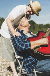Glückliches Seniorenpaar mit Gitarre - UUF005703