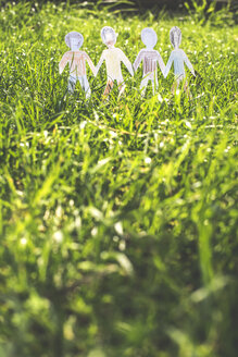 Chain of painted paper figurines on a meadow - DEGF000544