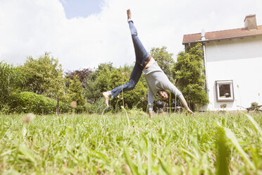 Man doing a cartwheel in garden - RBF003161