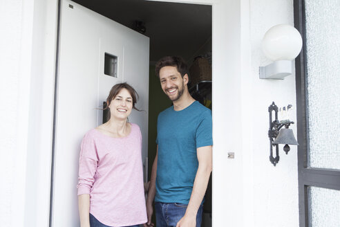 Porträt eines lächelnden Paares an der Haustür - RBF003178