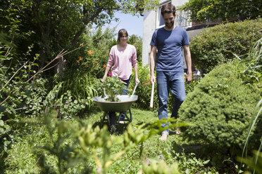 Couple with wheelbarrow gardening together - RBF003181