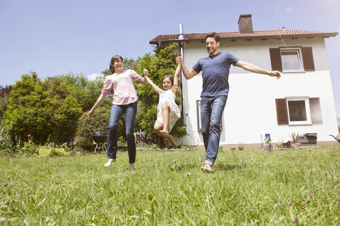 Verspieltes Paar mit Tochter im Garten - RBF003223