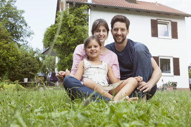 Porträt einer lächelnden Familie mit Tochter im Garten - RBF003211