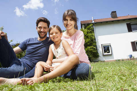 Porträt einer lächelnden Familie mit Tochter im Garten, lizenzfreies Stockfoto