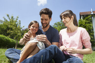 Glückliche Familie mit Tochter im Garten - RBF003215