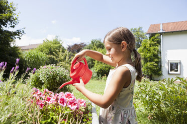 Mädchen im Garten, das Blumen gießt - RBF003183