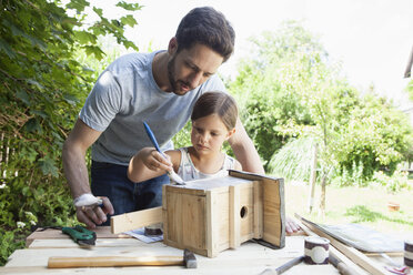 Father and daughter painting a birdhouse - RBF003232