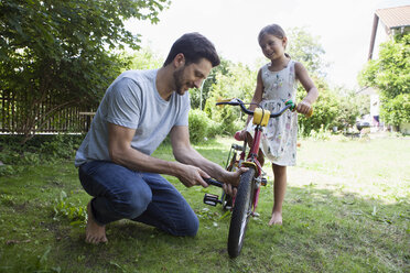 Father inflating daughter's bicycle - RBF003233