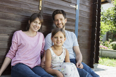 Portrait of smiling family with daughter at garden shed - RBF003234