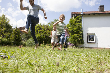 Sorglose Familie beim Laufen im Garten - RBF003238