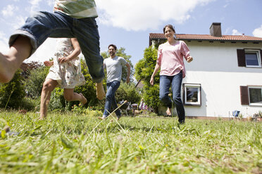 Sorglose Familie beim Laufen im Garten - RBF003184