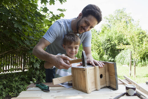 Vater und Sohn zimmern ein Vogelhaus - RBF003239