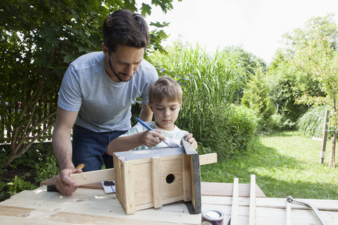 Vater und Sohn bauen ein Vogelhaus, lizenzfreies Stockfoto
