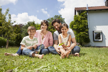 Porträt einer lächelnden vierköpfigen Familie im Garten - RBF003241