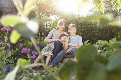 Glückliche Mutter, Sohn und Tochter im Garten - RBF003257