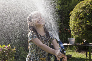 Girl splashing with water in garden - RBF003262