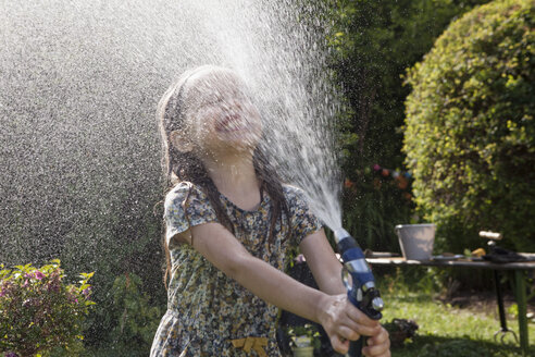 Girl splashing with water in garden - RBF003262