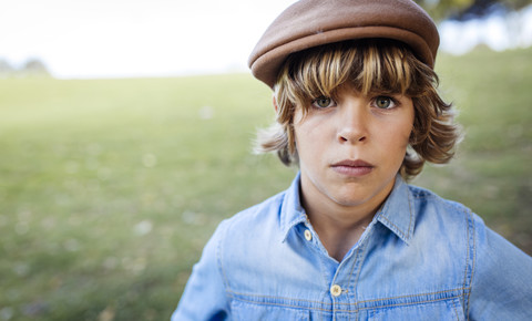 Portrait of serious looking blond boy wearing cap stock photo