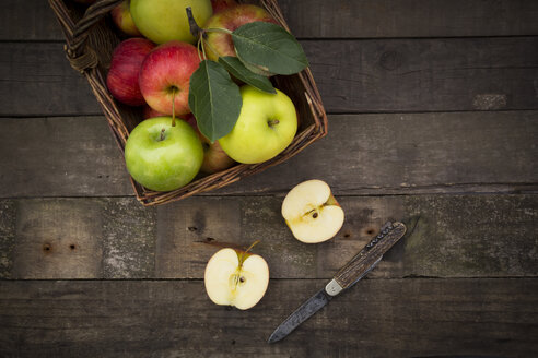 Verschiedene Äpfel, Korb und Taschenmesser auf Holz - LVF003843