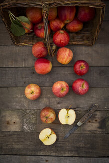 Rote Äpfel, Sorte Gala, Korb und Taschenmesser auf Holz - LVF003847