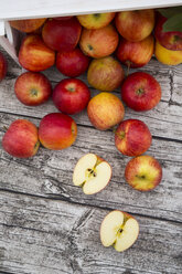 Ganze und geschnittene rote Äpfel auf Holz - LVF003865
