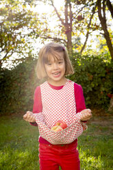 Portrait of little girl holding apples with her dress - LVF003873