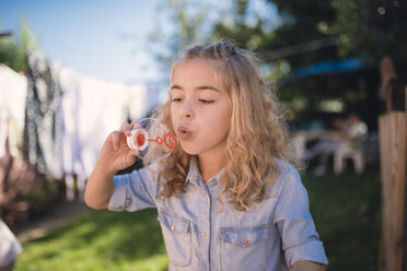 Little girl blowing soap bubbles - RAEF000501