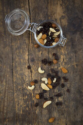 Mixed nuts and raisins in glass on wood - LVF003881
