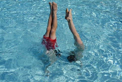 Teenager und Mädchen machen einen Handstand im Schwimmbad - LBF001205