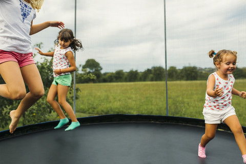 Three girls bouncing on trampoline stock photo