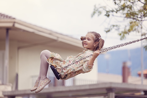 Glückliches kleines Mädchen auf einer Schaukel, lizenzfreies Stockfoto