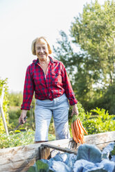 Smiling senior woman at vegetable patch - UUF005728