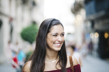 Porträt einer lächelnden jungen Frau in der Stadt - JRFF000085