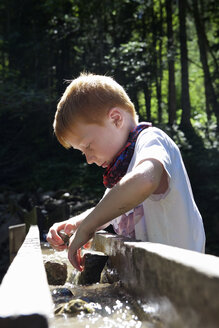 Boy playing at water runlet - JEDF000238
