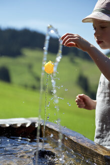 Boy playing with a small ball at fountain - JEDF000239