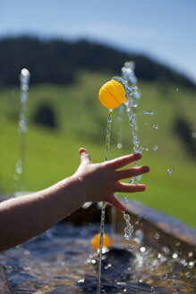 Boy playing with a small ball at fountain - JEDF000240