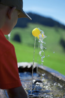 Boy playing with a small ball at fountain - JEDF000241