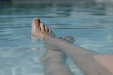 Bare feet of a girl in swimming pool - LBF001213