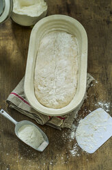 Loaf of bread in baking dish, raw dough, on wood - ODF001348