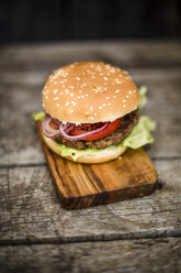 Hausgemachter Burger mit Salat, Fleisch, Tomate und Zwiebel auf Schneidebrett - SARF002134