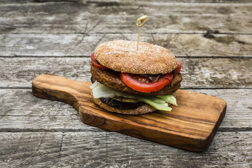 Hausgemachter Veggie-Burger mit Aubergine, Salat, Tomate und Zwiebel auf Schneidebrett - SARF002136