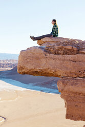 Chile, Atacama Desert, woman sitting on a cliff looking at view - GEMF000395