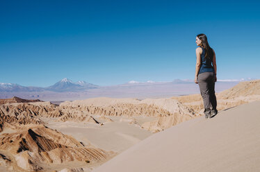 Chile, Atacama Desert, woman standing on a dune looking at view - GEMF000397