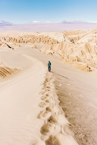 Chile, Atacama-Wüste, Mann klettert auf eine Düne, lizenzfreies Stockfoto