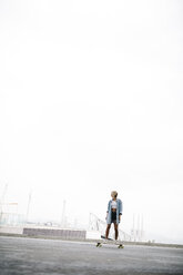 Young woman standing on a longboard - JRFF000089