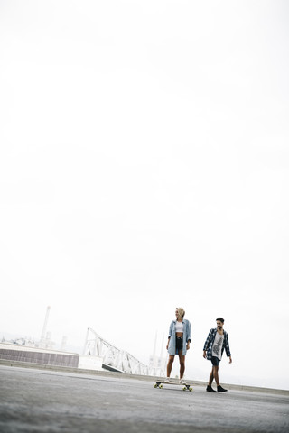 Freunde beim Longboarden auf der Straße, lizenzfreies Stockfoto