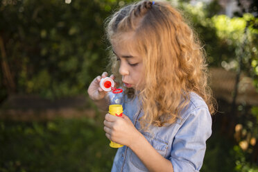 Blond little girl blowing soap bubble - RAEF000512